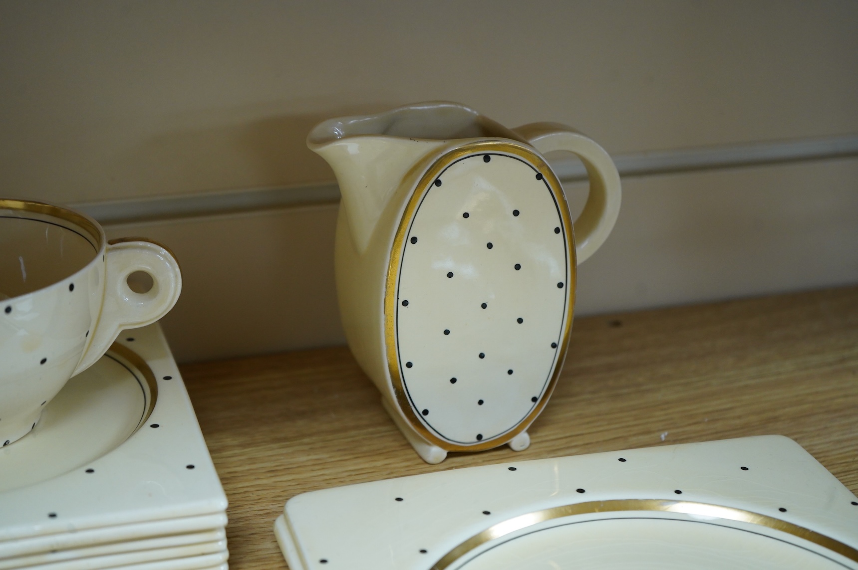 A Clarice Cliff Biarritz-shape 21-piece part teaset including trencher plates and saucers, impressed date-code 1935, jug 13cm